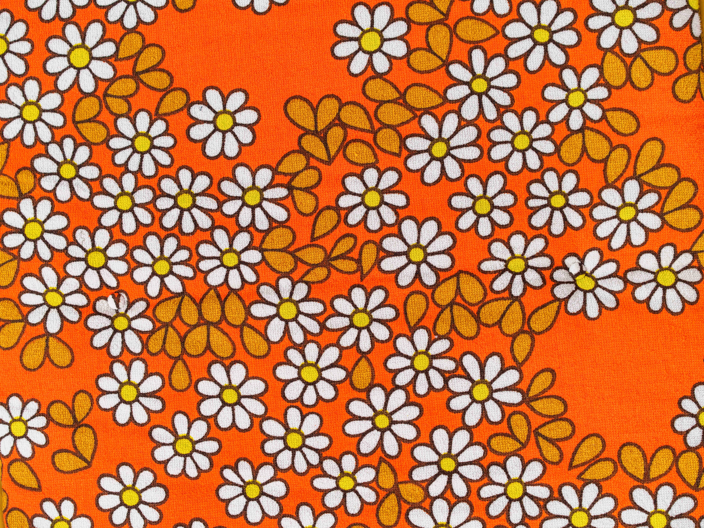 Vue rapprochée du tissu éponge vintage du matelas de plage Daisy ’73, motif marguerites orange, blanc et jaune des années 70 avec boutons recouverts