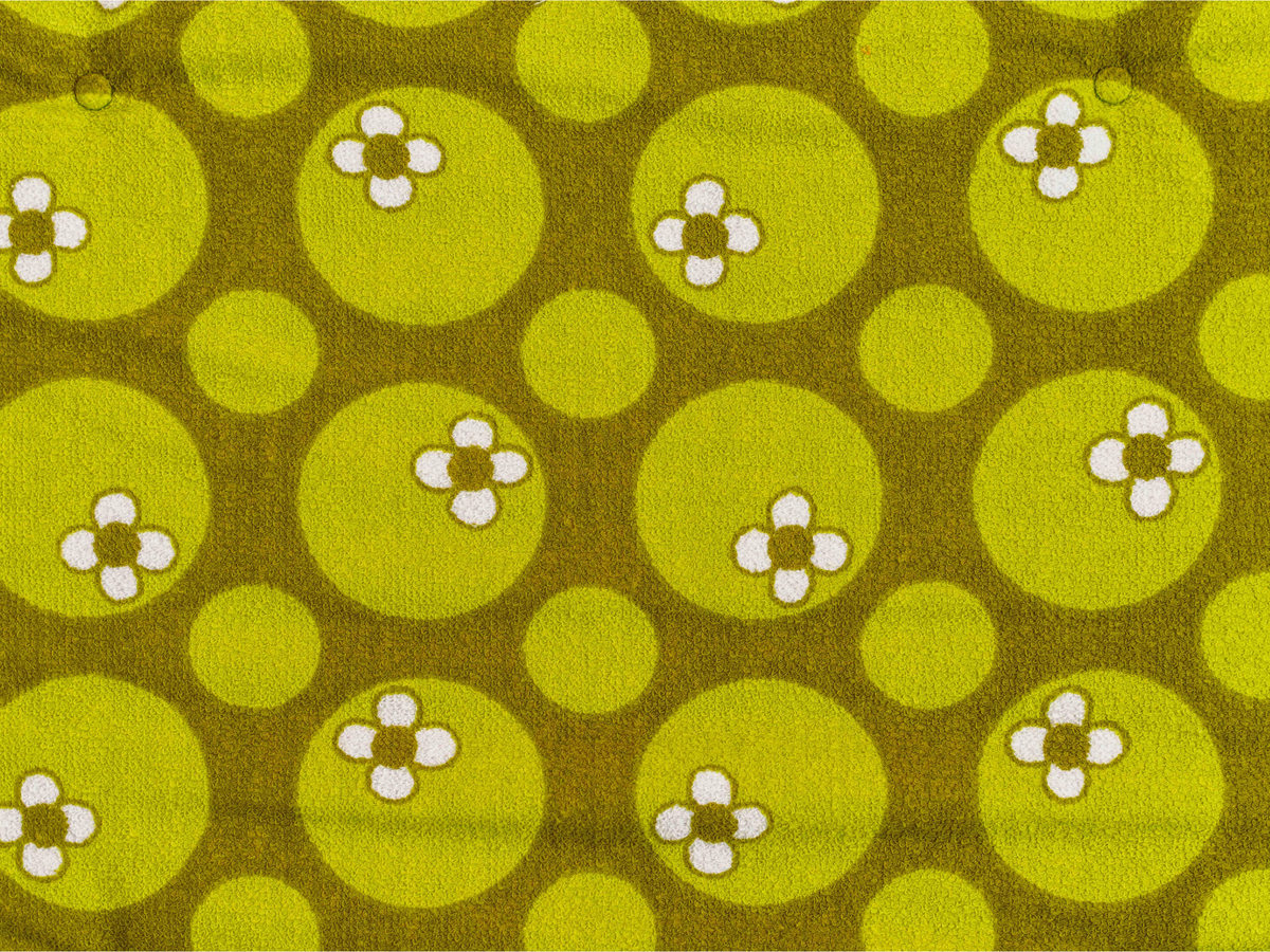 Vue rapprochée du tissu éponge vintage du matelas de plage Linden ’71, motif floral vert et blanc des années 70 avec boutons recouverts