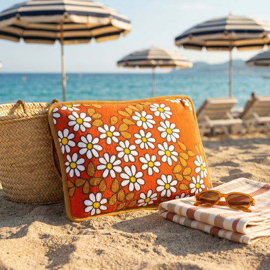 Coussin de plage vintage Daisy ’73 en tissu éponge fleuri orange des années 70, photographié sur la plage