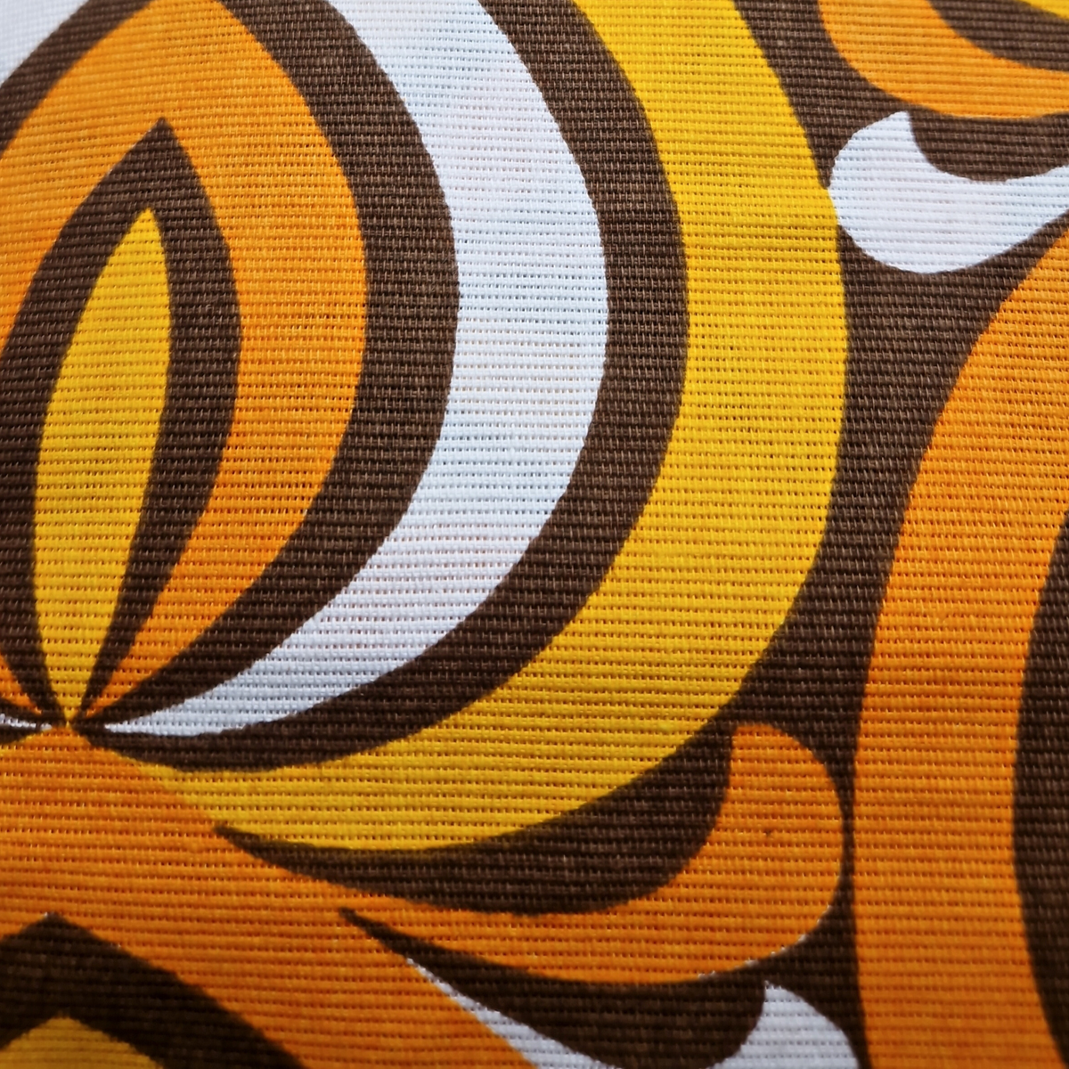 Détail du tissu vintage en coton du coussin Amber Arch, motif graphique orange, jaune et marron années 70