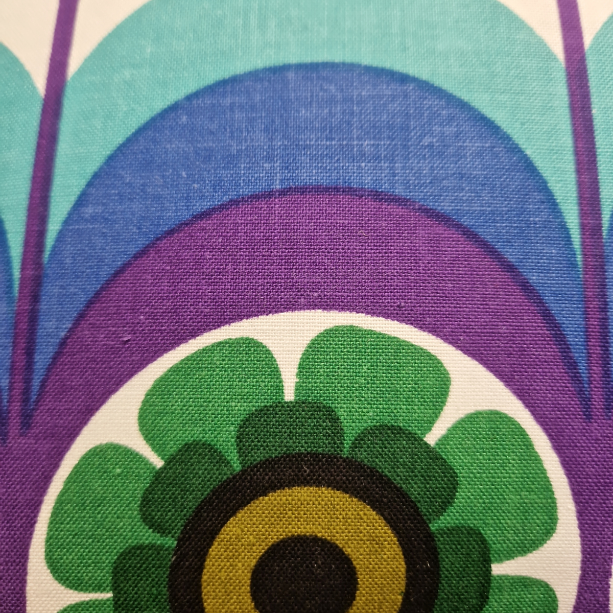Détail du tissu vintage en coton du coussin Cosmic Bloom, motif graphique années 70 turquoise, bleu, violet et vert.