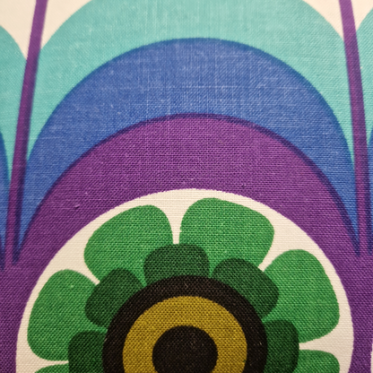 Détail du tissu vintage en coton du coussin Cosmic Bloom, motif graphique années 70 turquoise, bleu, violet et vert.