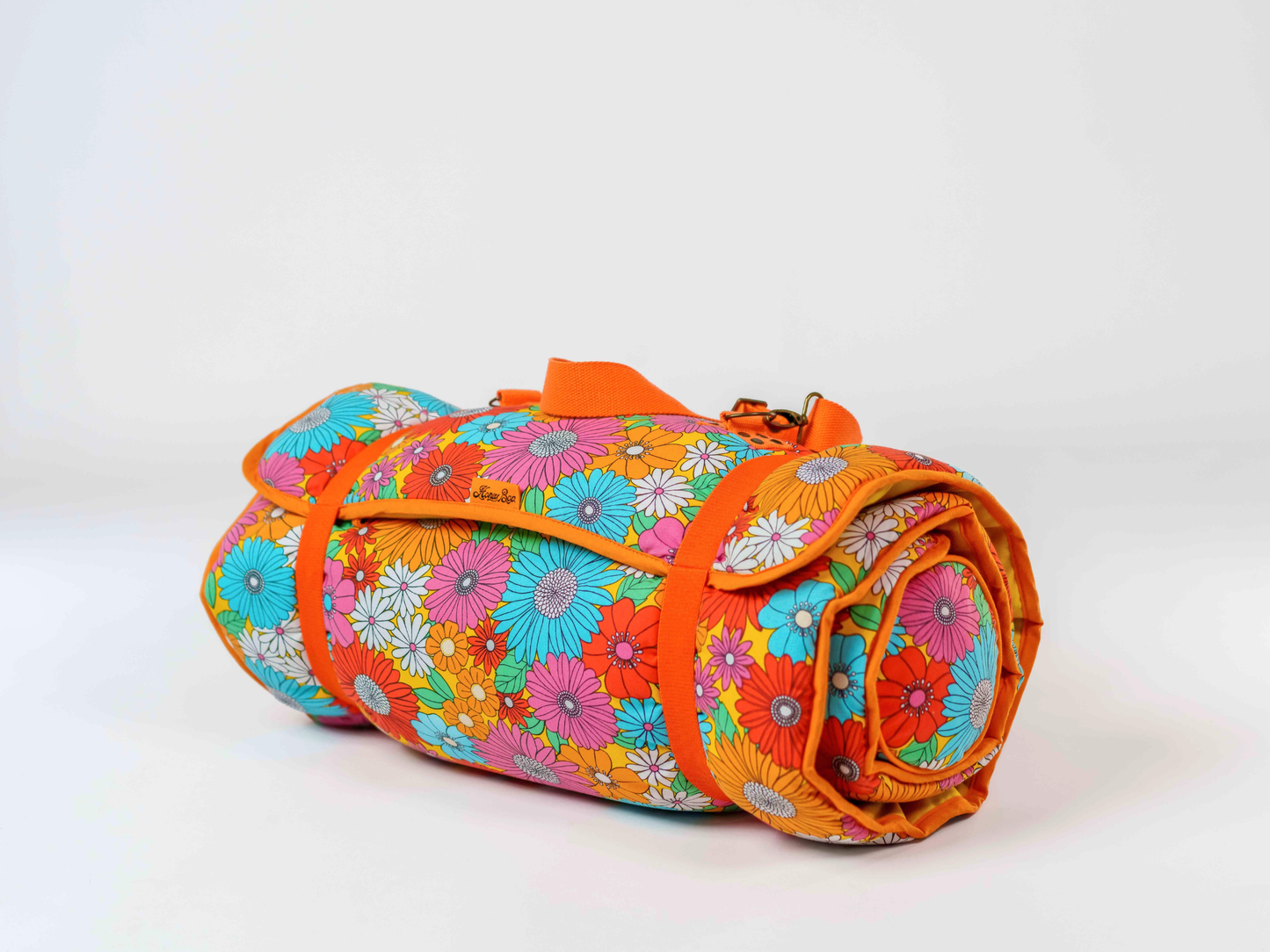 Matelas de plage Bloom ’72 roulé, à motif floral multicolore, avec sangle de transport amovible