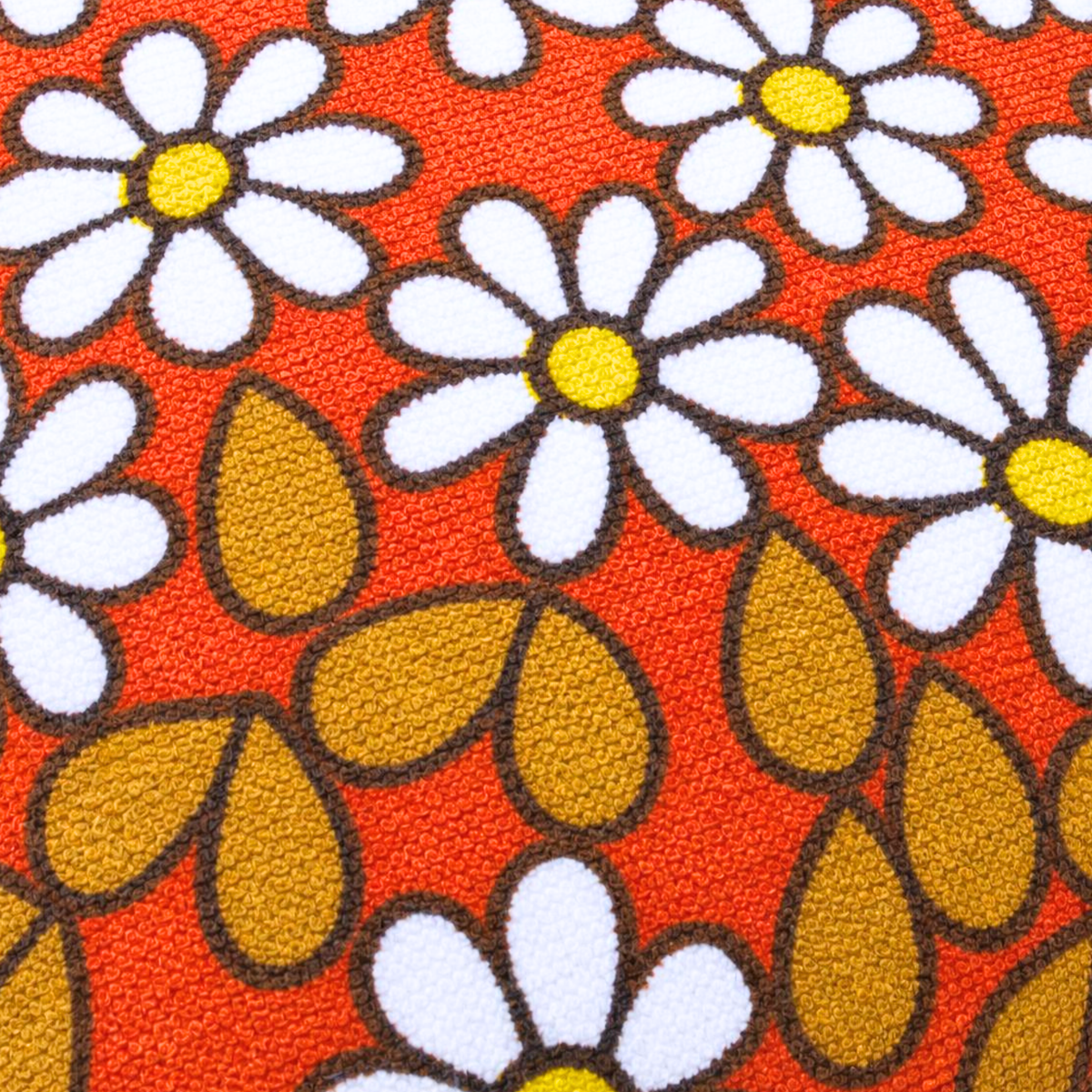 Gros plan du tissu éponge vintage du coussin de plage Daisy ’73, motif floral orange, blanc et ocre des années 70