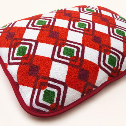 Détail du coussin de plage vintage Ruby ’72 en tissu éponge rouge, orange, vert et blanc, motif géométrique et finition en biais bordeaux