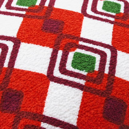 Gros plan du tissu éponge vintage du coussin de plage Ruby ’72, motif géométrique rouge, blanc, bordeaux et vert des années 70
