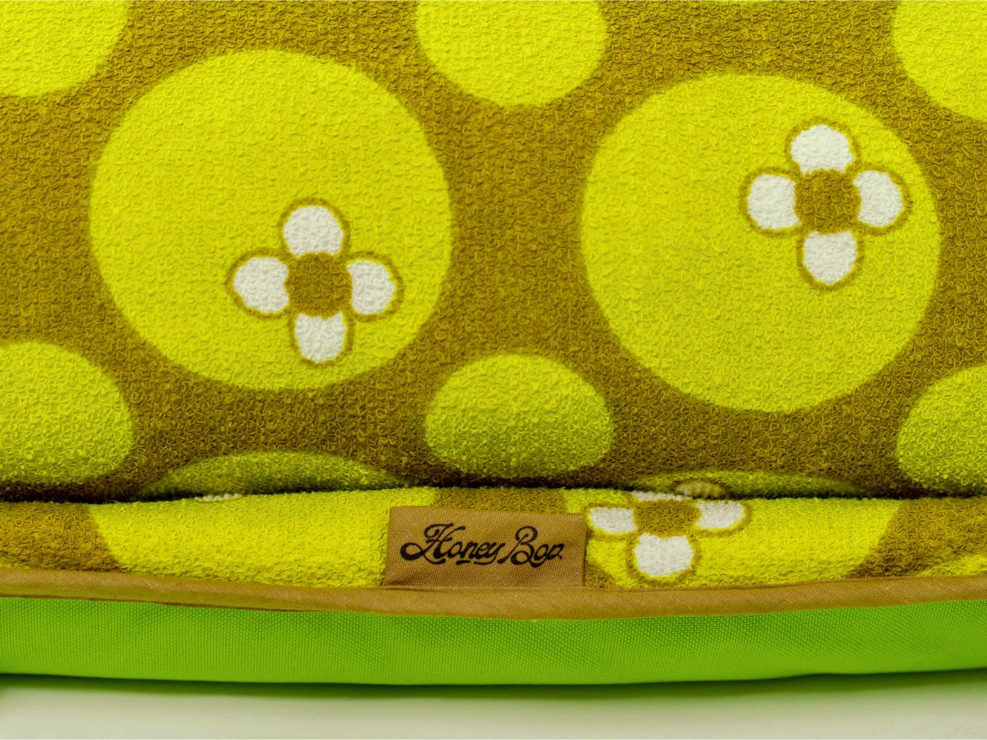 Détail du tissu éponge vintage du matelas de plage Linden ’71, motif floral vert des années 70 avec étiquette Honey Bop