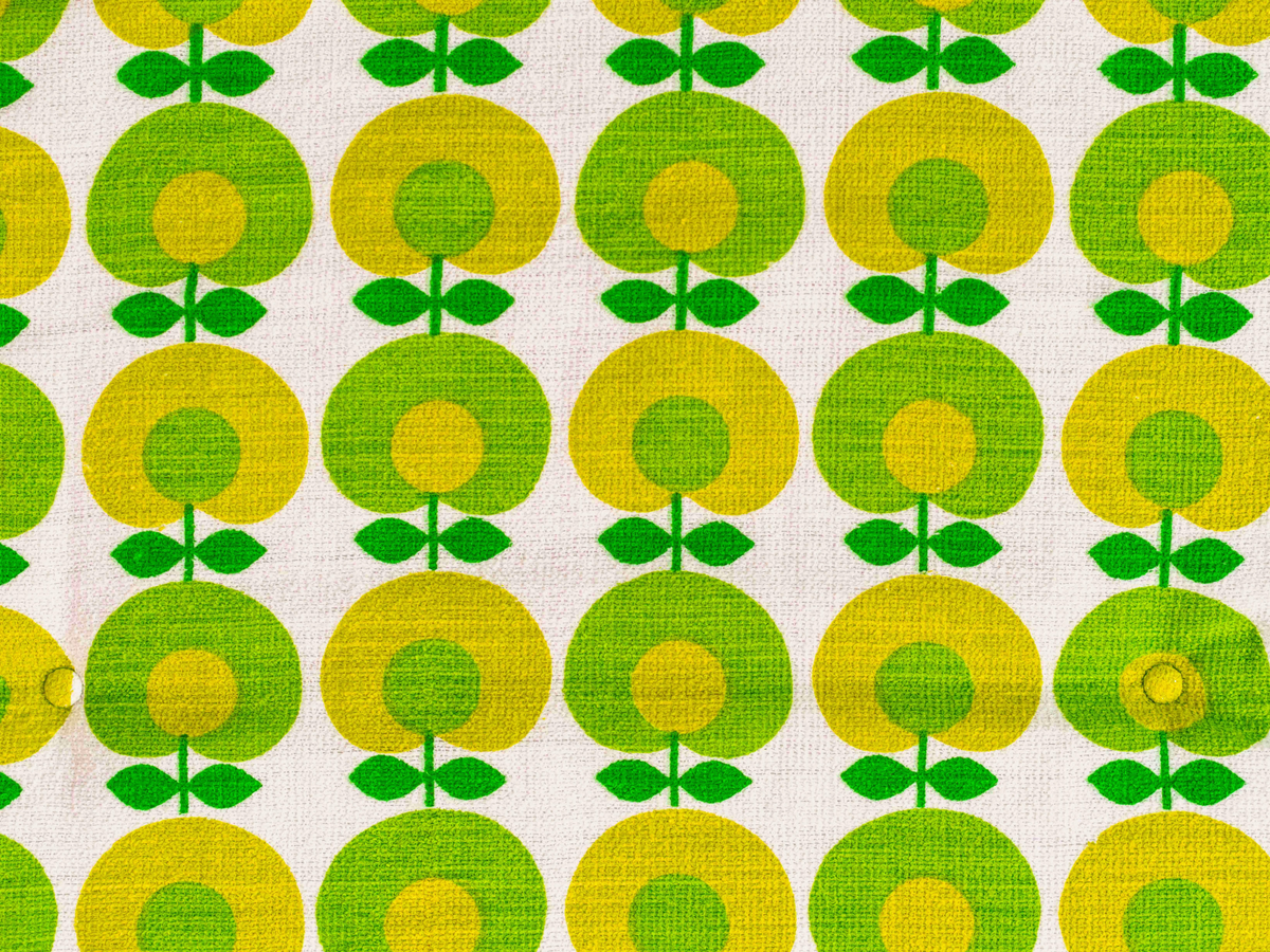 Détail du tissu éponge vintage du matelas de plage Oliva ’71, motif floral géométrique vert, jaune et blanc des années 70 avec boutons recouverts