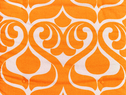 Gros plan du tissu éponge vintage du matelas de plage Sirocco ’71, motif orange et blanc des années 70 avec boutons recouverts