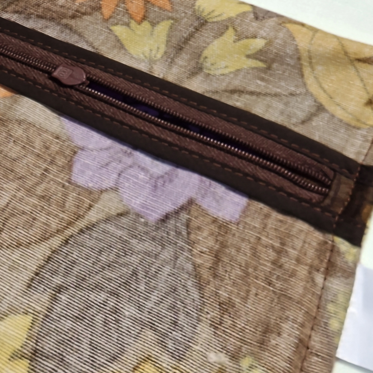 Détail des finitions intérieures et de la fermeture du coussin vintage Harvest Bloom en tissu des années 70