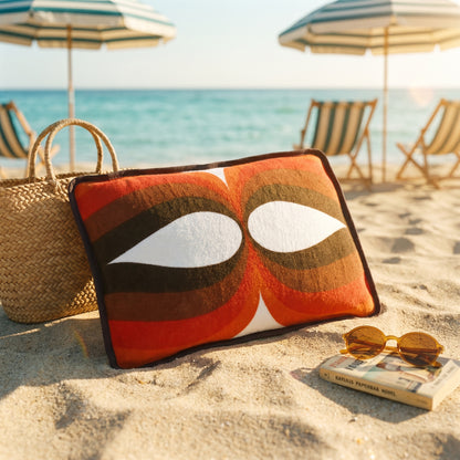 Coussin de plage vintage Riviera ’74 en tissu éponge à motif géométrique orange, marron et blanc des années 70, photographié sur la plage